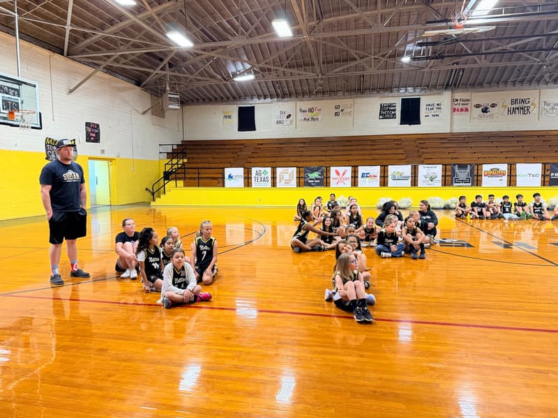 Nettes players sit on the court while a coach looks on