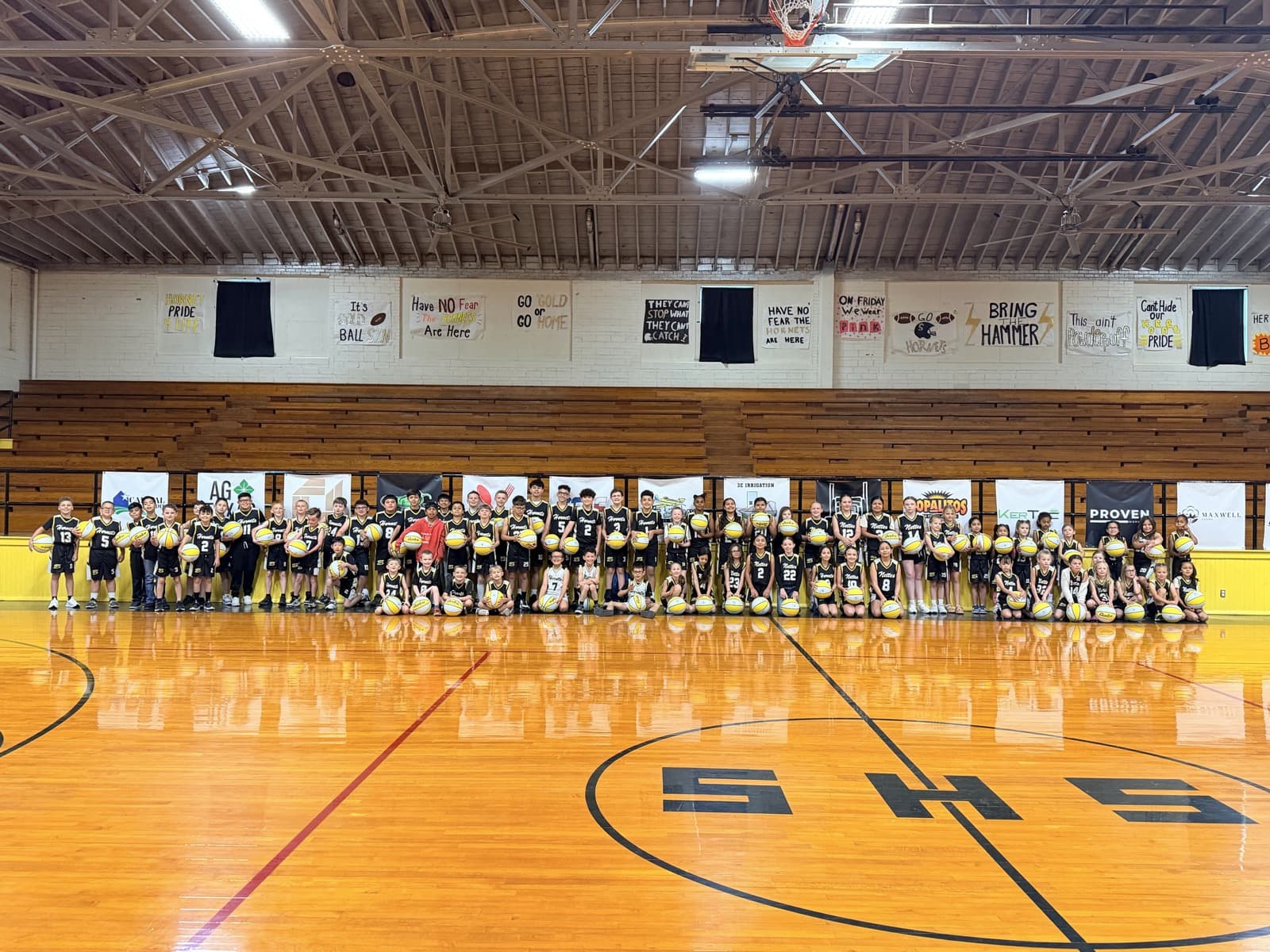 The whole league, dozens of players in black and gold Hornets and Nettes jerseys, lined up in the Old Gym holding basketballs